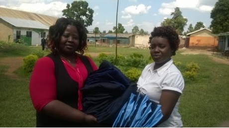 A social worker receiving uniforms from the Head teacher to distribute to Southend Academy