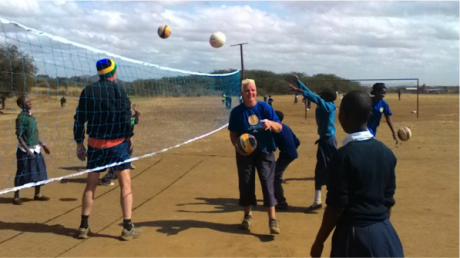 Above, CtC members on volleyball ground during the volleyball training session at Kisongo primary school. Far at the background of the photo, other group