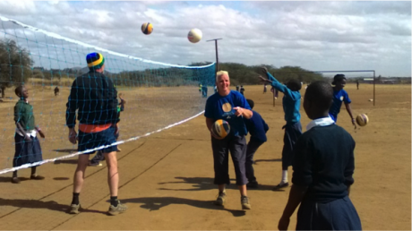 Above, CtC members on volleyball ground during the volleyball training session at Kisongo primary school. Far at the background of the photo, other group 